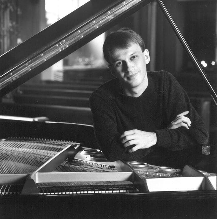 Graham Scott leaning on piano