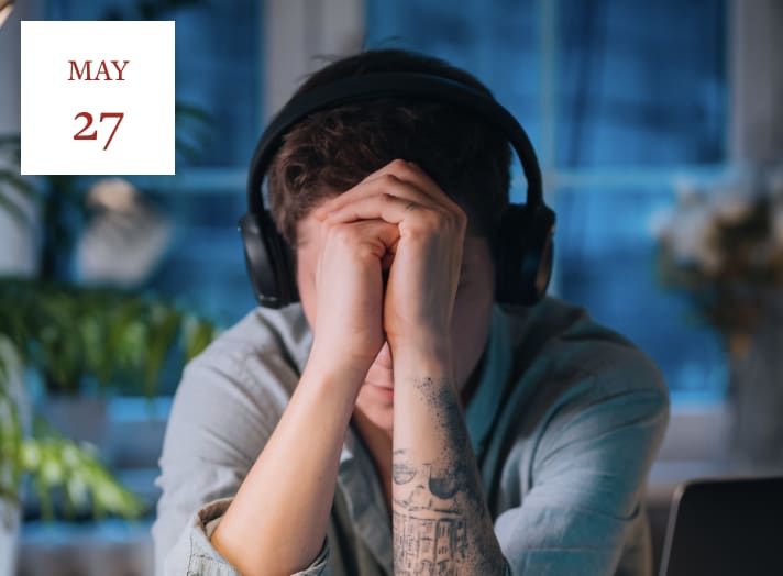 Man wearing headphones has his head in his hands